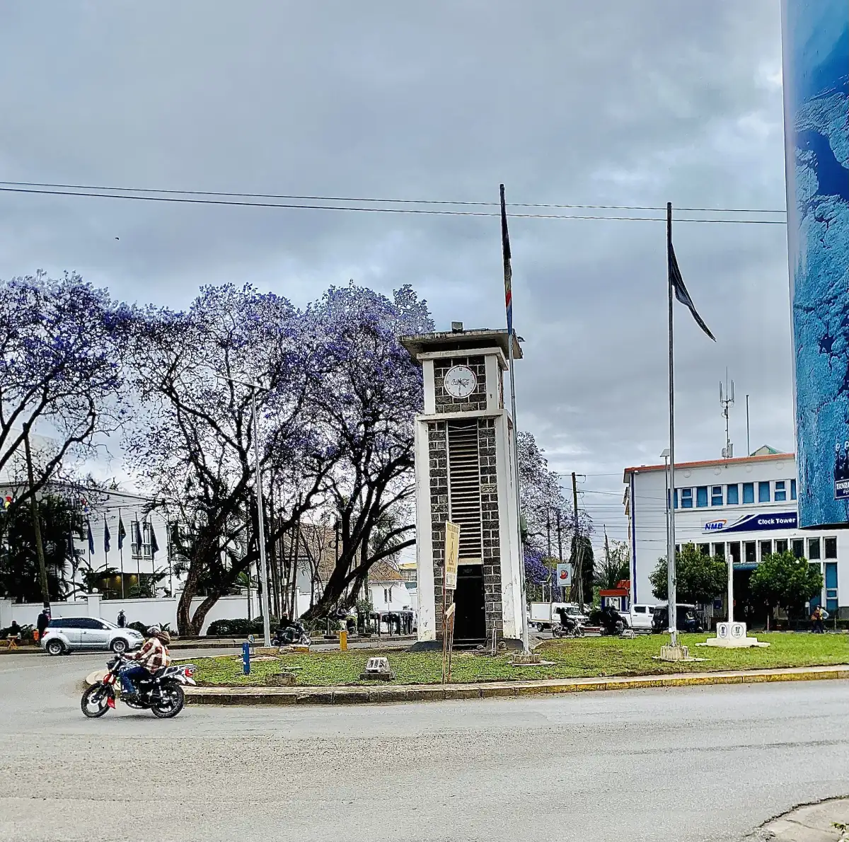 De klokkentoren van Arusha tussen bloeiende jacarandabomen