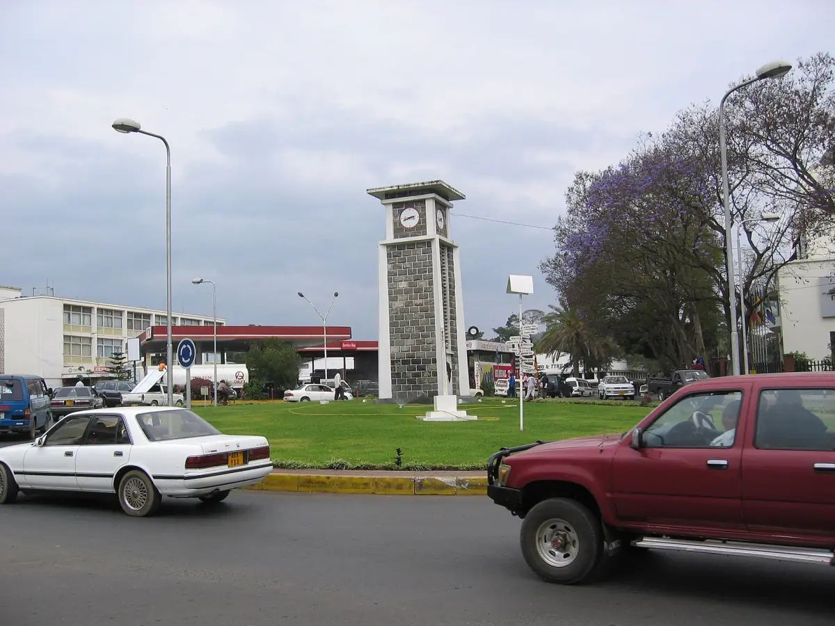 Der Uhrturm von Arusha auf seinem Kreisverkehr mit vorbeifahrenden Autos