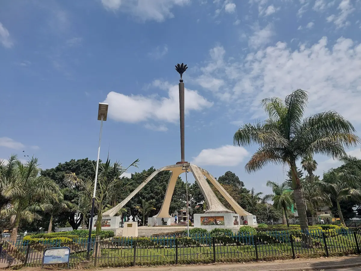 Das Arusha-Declaration-Denkmal mit hoher Fackel über einem Betonbogen