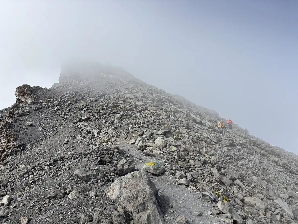 Wandelaars op een puinhelling nabij de top van Mount Meru