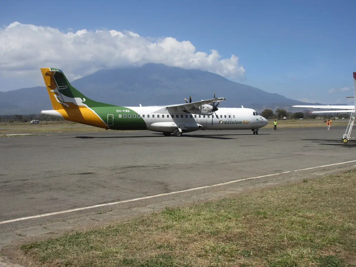 Propellerflugzeug auf dem Vorfeld mit dem Mount Meru im Hintergrund