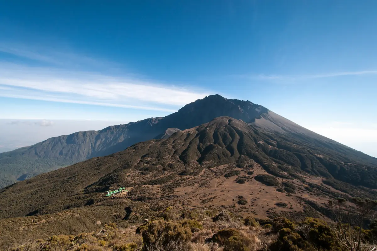 Der Vulkan Mount Meru erhebt sich unter tiefblauem Himmel über der Ebene
